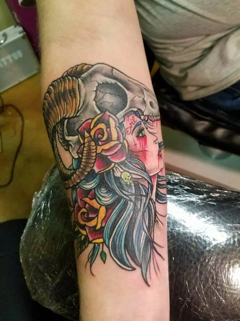 A tattoo of a woman with a skull and roses.