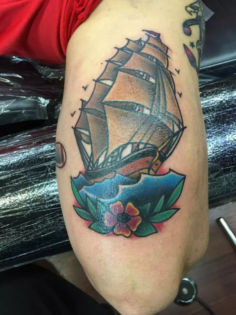 Tattoo; ship; flowers.