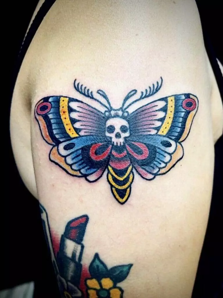 A tattoo of a moth with a skull on it.