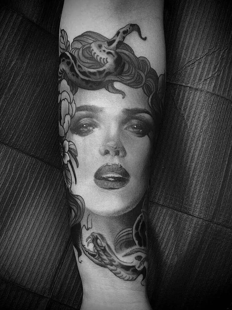 A black and white tattoo of a woman's face.