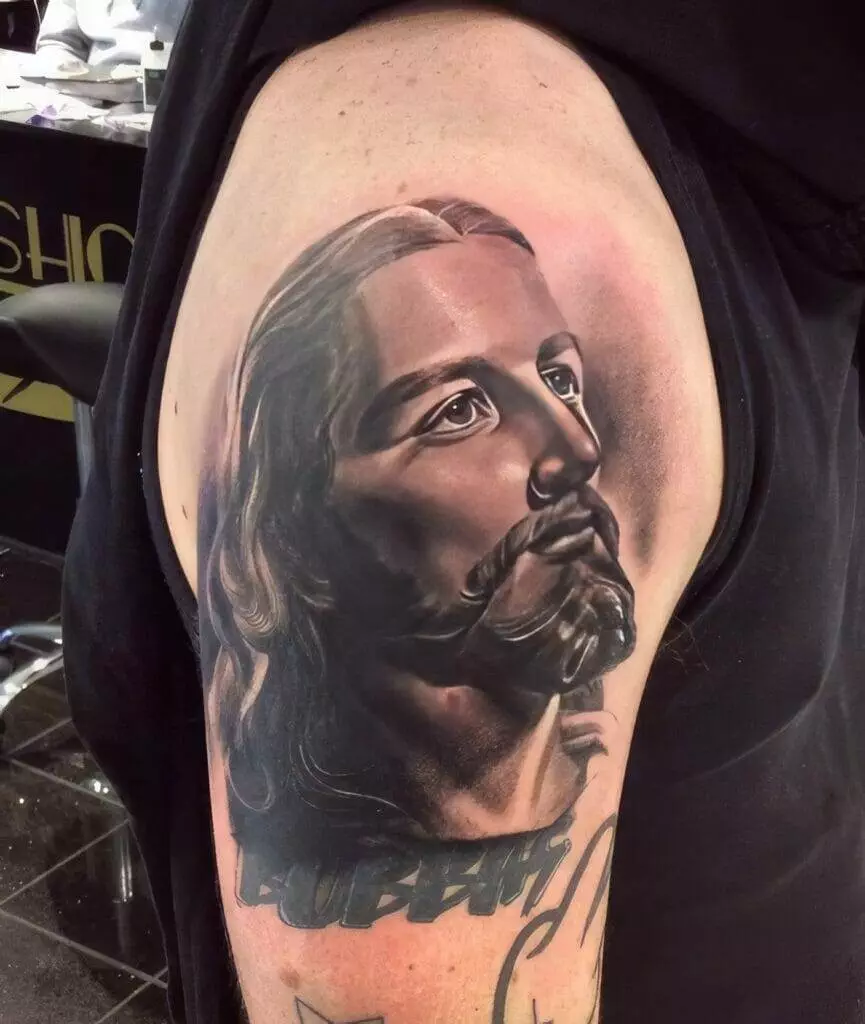 A tattoo of jesus on a man's arm.