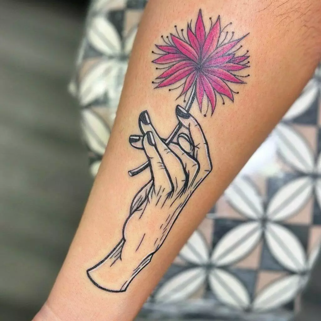 A tattoo of a hand holding a flower.