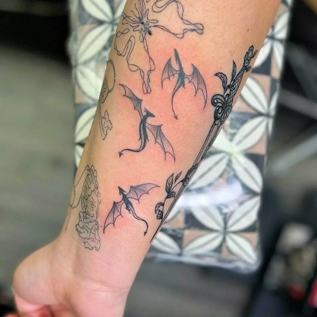 A tattoo of dragons on a woman's forearm.