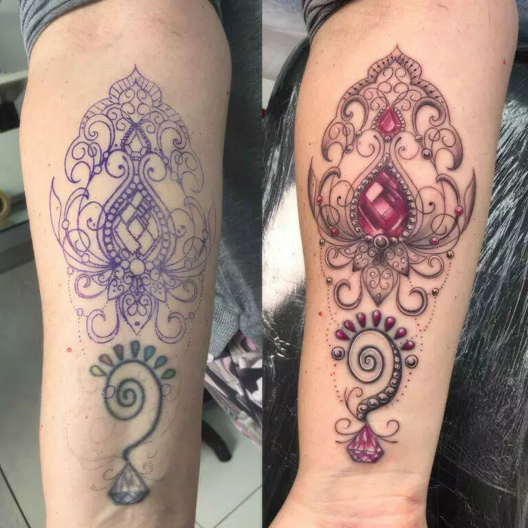 A woman has a tattoo on her arm with an ornate design.