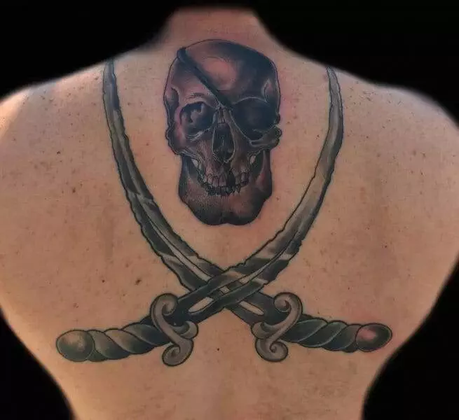 A man with a skull and two swords tattooed on his back.