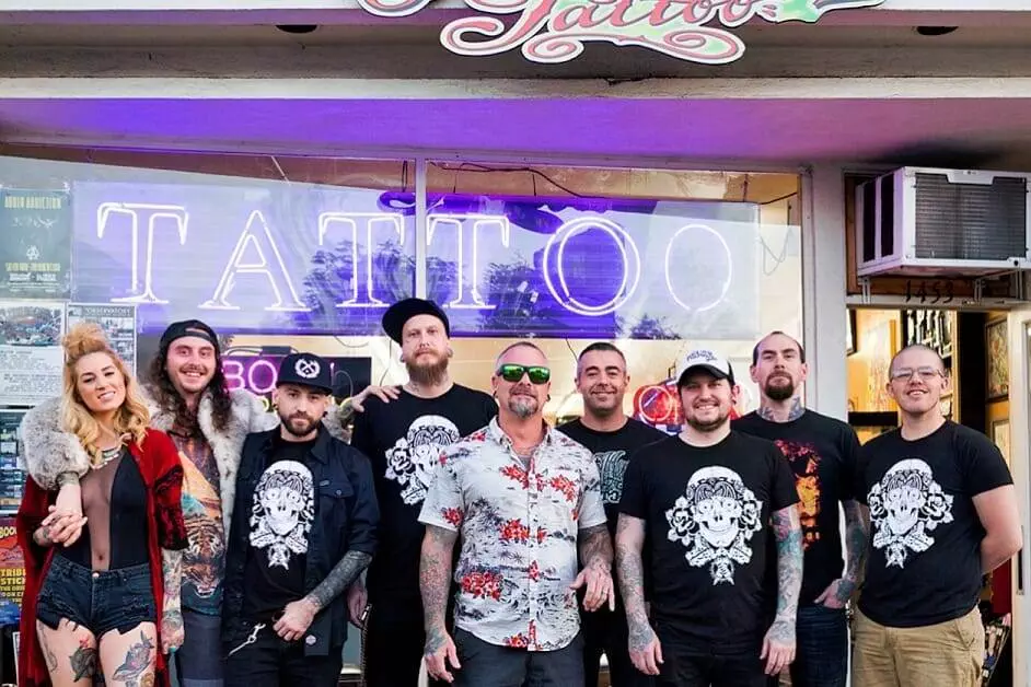 A group of people standing in front of a funhouse tattoo shop in San Diego.