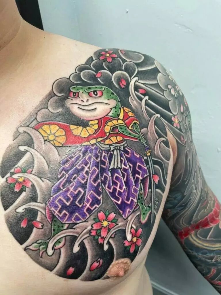 A man with a tattoo of a frog on his chest.