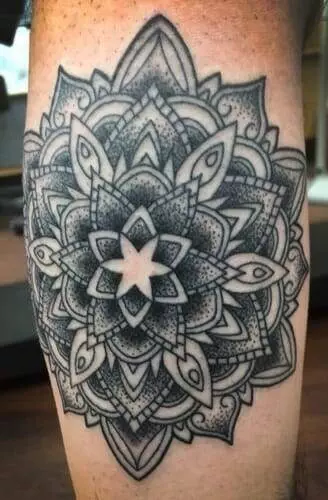 A mandala tattoo on a man's thigh.