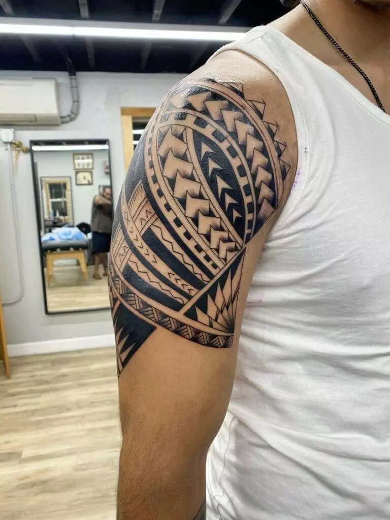 A man with a tribal tattoo on his arm.