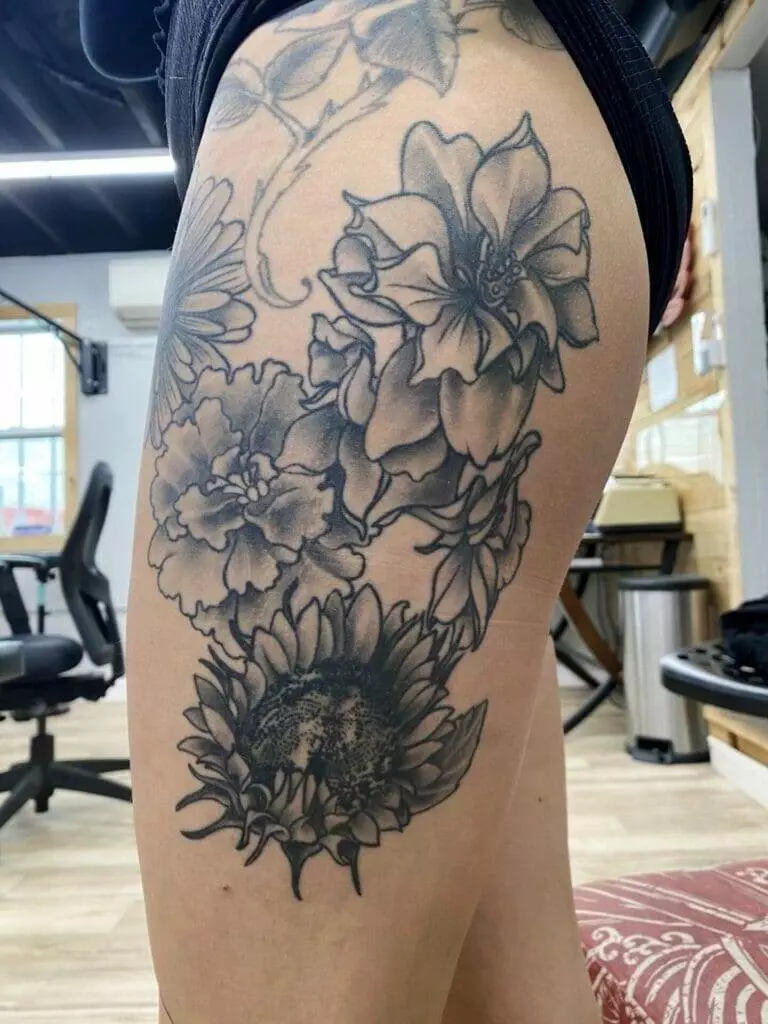 A woman with a flower tattoo on her thigh.