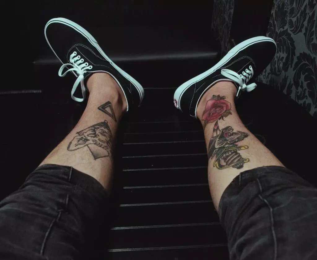 A person's legs with tattoos on them.