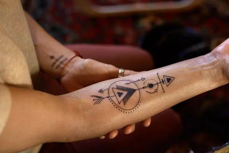 A woman showcasing an intriguing tattoo on her arm, transforming it into a stunning work of art.