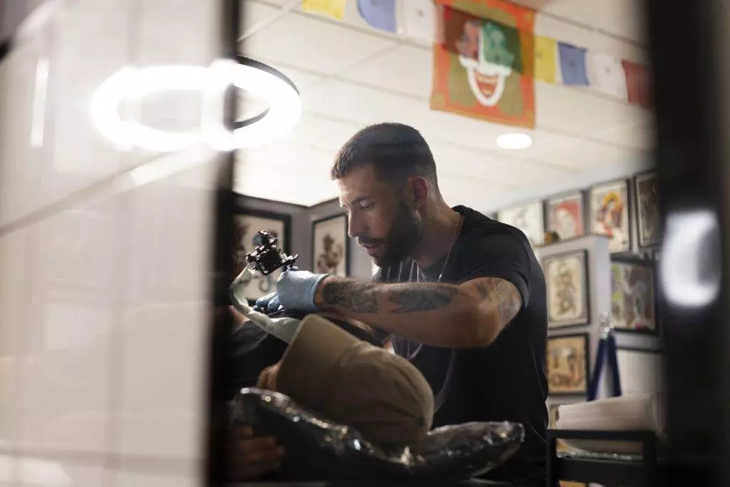 A man receiving a cover-up tattoo, transforming his unwanted ink into a work of art, at a tattoo shop.