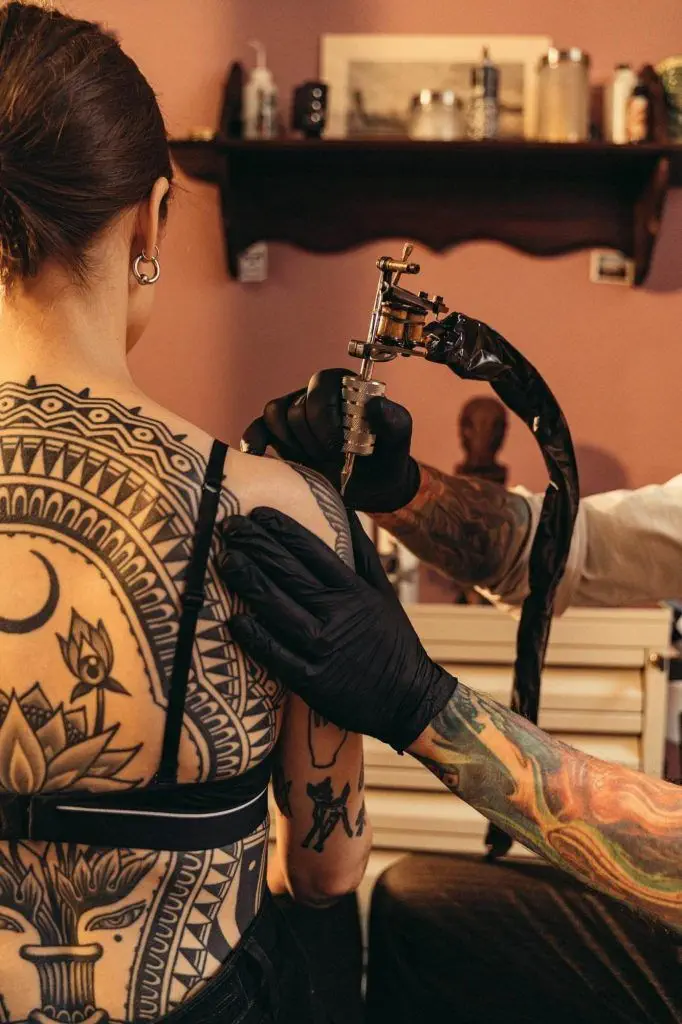 A Person Putting Tattoo on the Woman's Skin